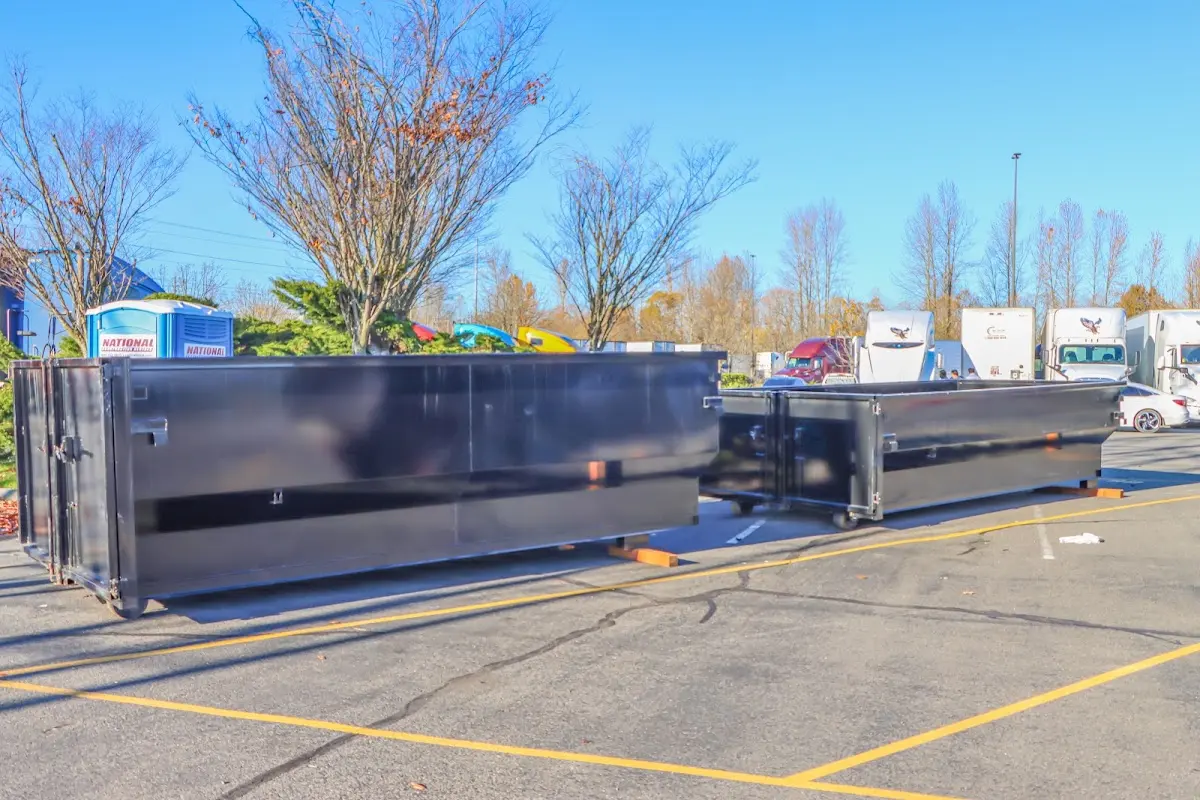 Professional dumpster rental service with roll-off container on residential driveway in East Troy